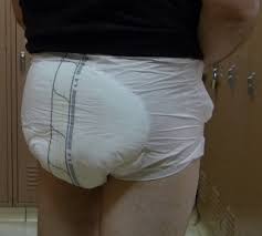 A man with diaper he is in bathroom showing his back pose