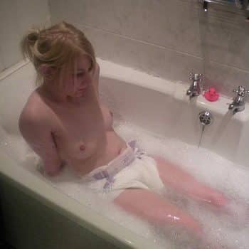 Small girl bathing with foam in a bathtub